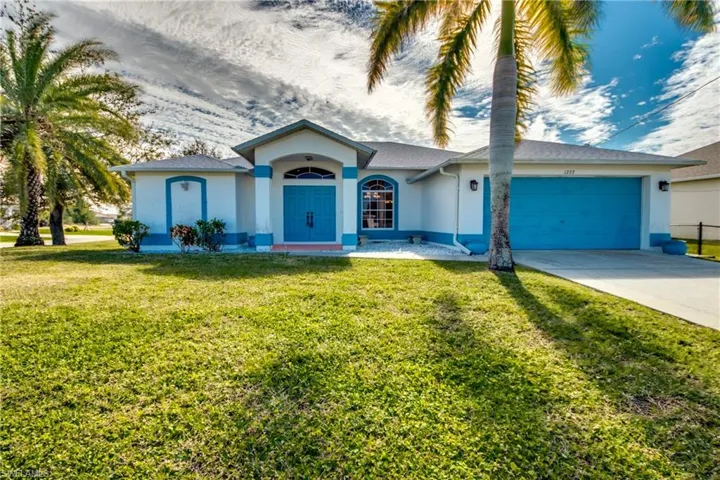 Ranch-style home featuring a garage and a front yard