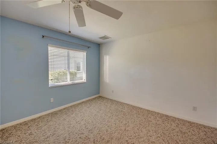 Unfurnished room featuring carpet floors and ceiling fan