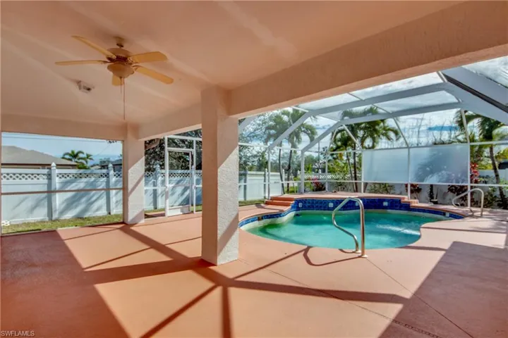 View of pool with a lanai, ceiling fan, and a patio area