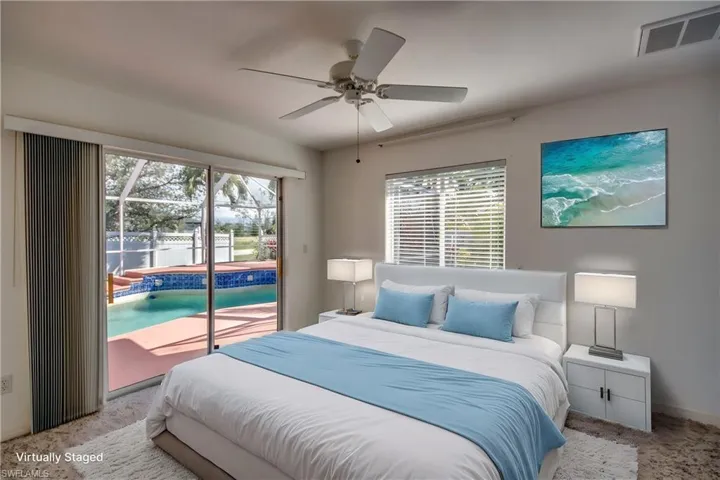 Bedroom featuring multiple windows, light carpet, access to outside, and ceiling fan