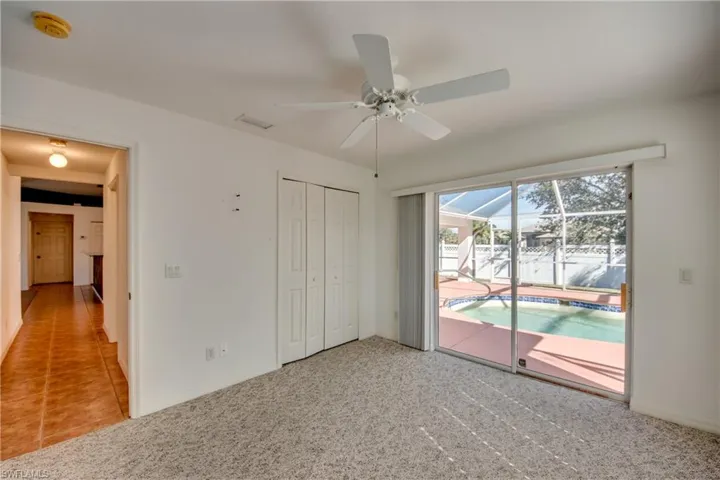 Unfurnished bedroom featuring ceiling fan, a closet, carpet, and access to outside