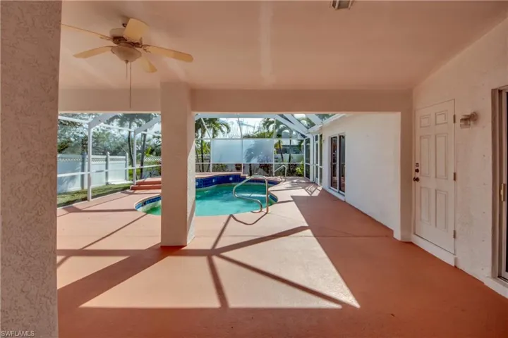 View of swimming pool featuring a lanai, ceiling fan, and a patio area