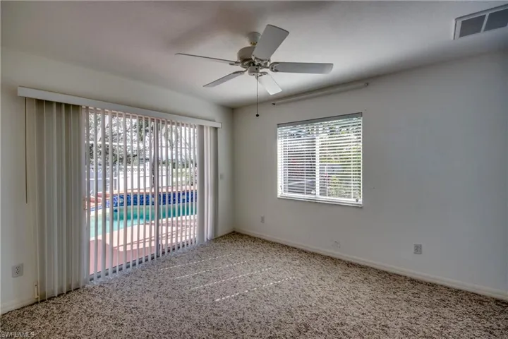 Carpeted empty room featuring ceiling fan