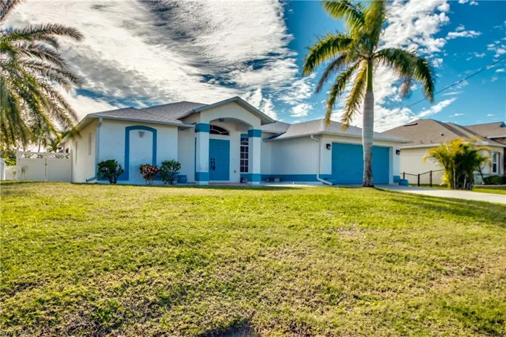 Single story home with a garage and a front yard
