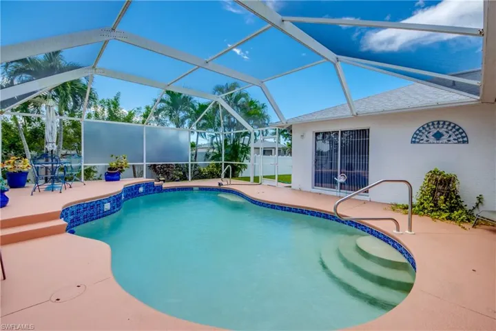 View of swimming pool featuring a patio area and glass enclosure