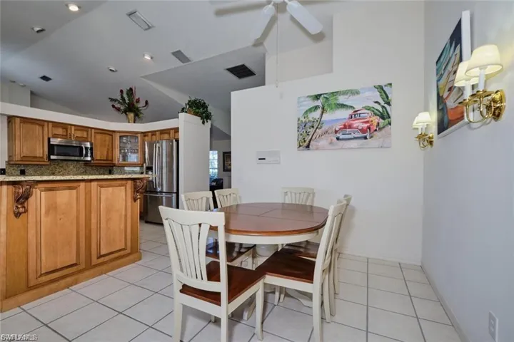 Dining room featuring light tile patterned floors, high vaulted ceiling, and ceiling fan
