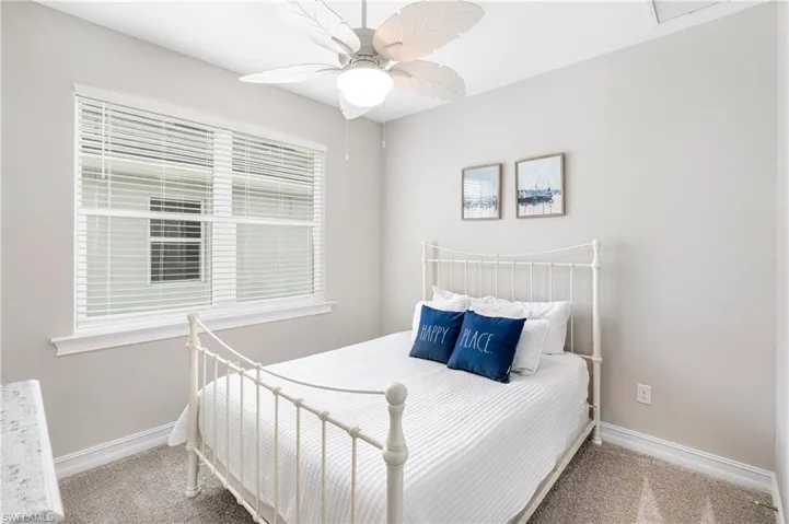 Carpeted bedroom featuring a ceiling fan and baseboards