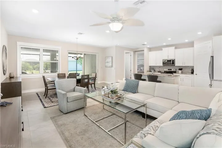 Living room with recessed lighting, a chandelier, light tile patterned floors, and ceiling fan
