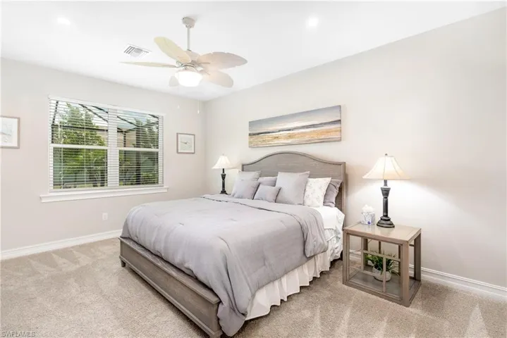 Carpeted bedroom featuring ceiling fan and recessed lighting
