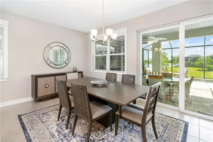 Dining room with healthy amount of natural light, light tile patterned floors, and a chandelier