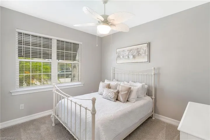 Carpeted bedroom featuring a ceiling fan and baseboards