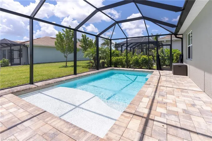 Outdoor pool with a sunroom, a lawn, a lanai, and a patio