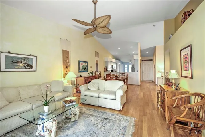 Living room featuring high vaulted ceiling, ceiling fan, and bamboo flooring