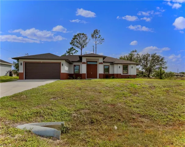 View of front facade with a front lawn and a garage