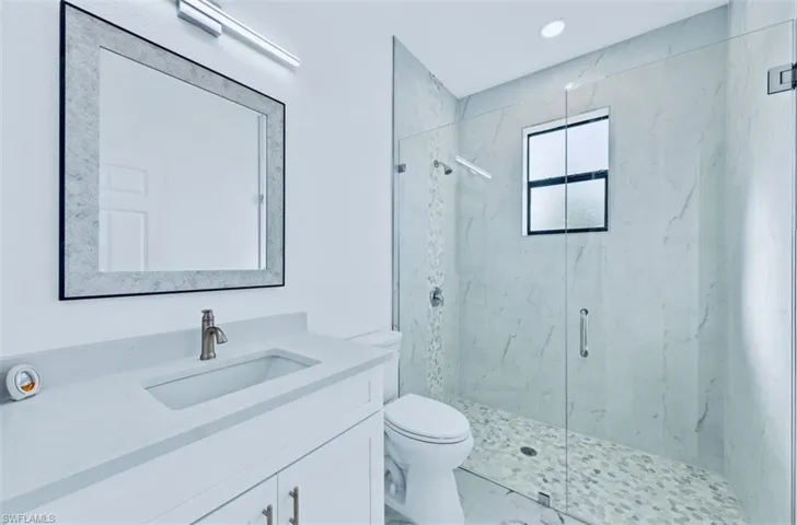 Bathroom with walk in shower, vanity, and toilet