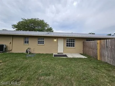 Rear view of house featuring a patio, stucco siding, and a fenced backyard