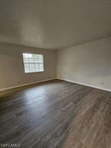 Spare room with dark wood finished floors and a textured ceiling