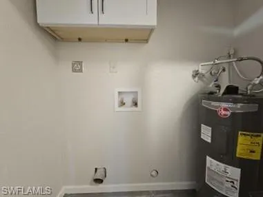 Laundry room featuring electric water heater, cabinet space, gas dryer hookup, and washer hookup