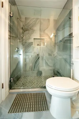 Full bathroom with a marble finish shower