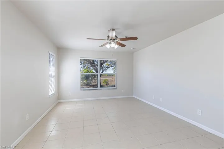 Spare room with ceiling fan and light tile patterned floors