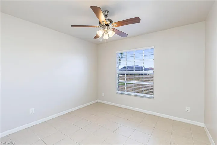 Unfurnished room featuring a ceiling fan and light tile patterned flooring