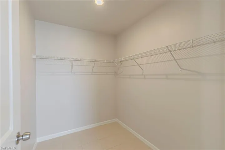 Walk in closet with light tile patterned flooring