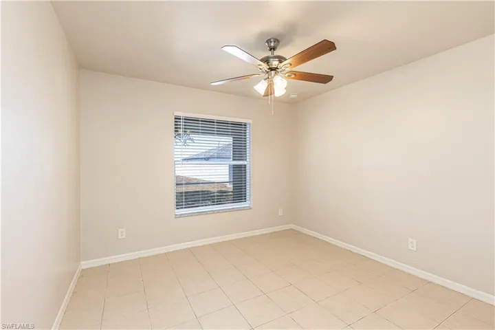 Unfurnished room with a ceiling fan and light tile patterned floors