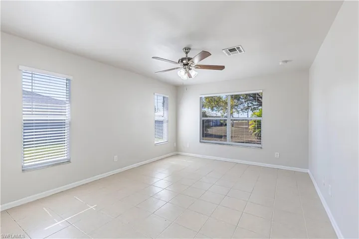 Spare room featuring ceiling fan and light tile patterned floors