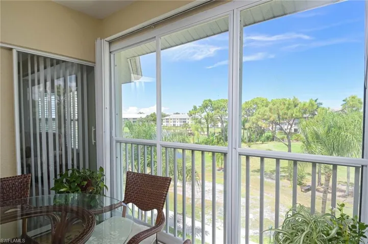 Lanai with sliding doors and storm shutters overlooking the lake and golf course.