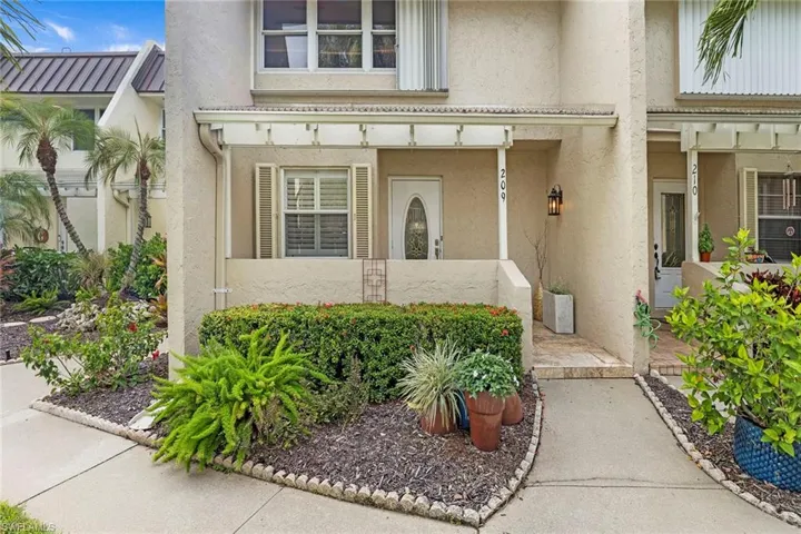 Property entrance with stucco siding and a porch