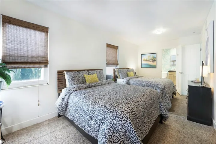 Bedroom with light carpet and connected bathroom