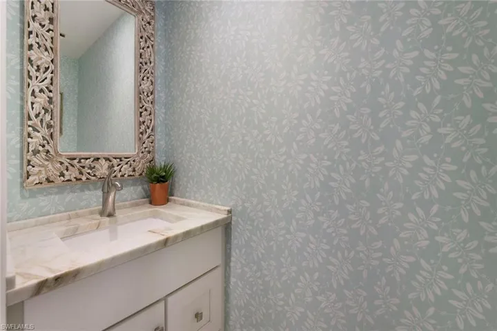 Bathroom with vanity and wallpapered walls