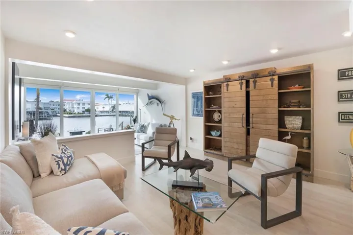 Living room with a water view, wood finished floors, and recessed lighting