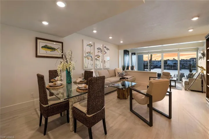 Dining room featuring a water view, light wood-style flooring, and recessed lighting