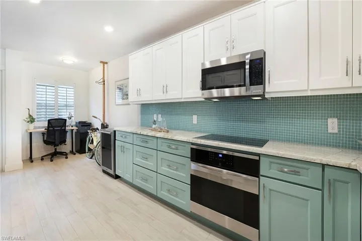 Kitchen with green cabinetry, white cabinetry, stainless steel appliances, tasteful backsplash, and recessed lighting