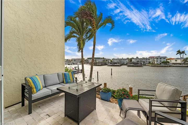 View of patio with a water view, outdoor lounge area, and a boat dock