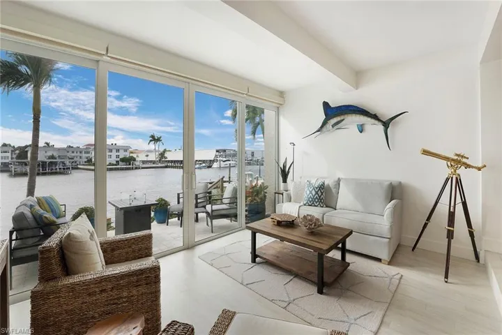 Living area featuring wood finished floors, a water view, and beam ceiling