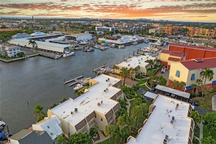 Aerial view at dusk of a water view, view of marina, and a city view