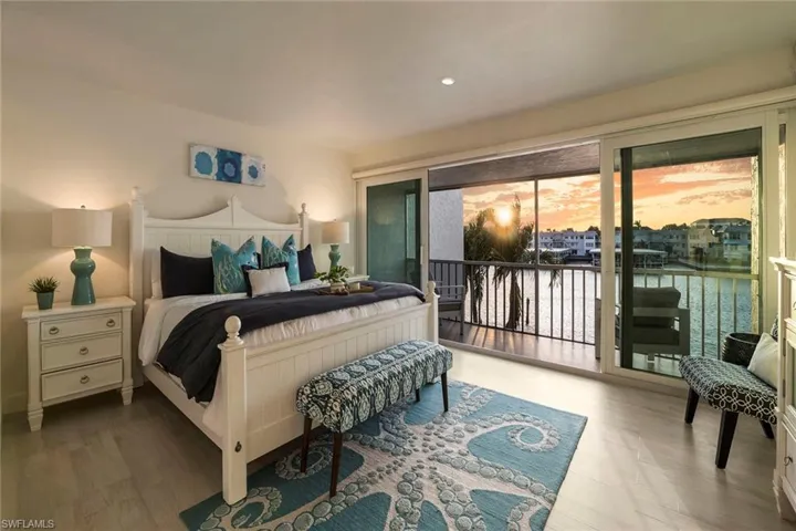 Bedroom with access to outside, wood finished floors, recessed lighting, and a water view