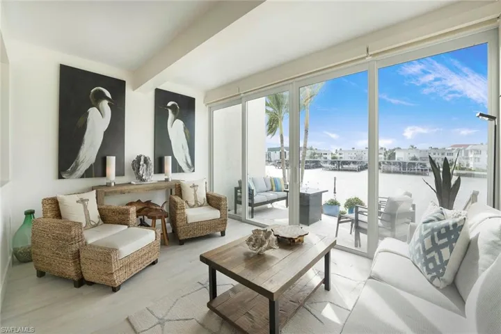 Living area with a water view, wood finished floors, and beamed ceiling