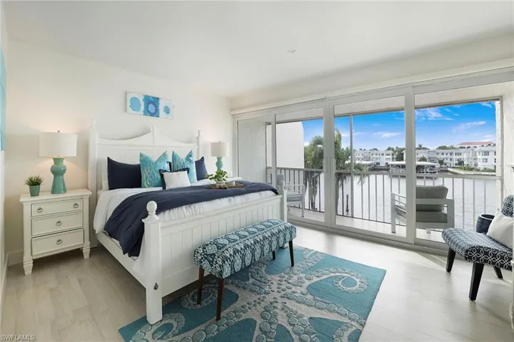 Bedroom with access to outside, light wood-style floors, and a water view