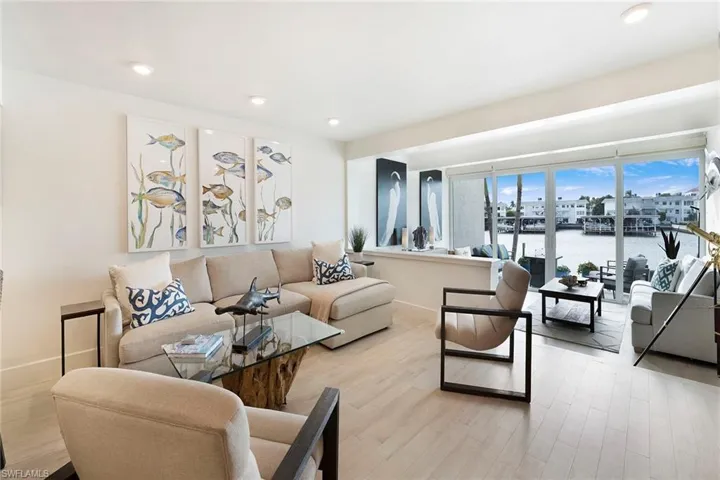 Living area with a water view, recessed lighting, and wood finished floors