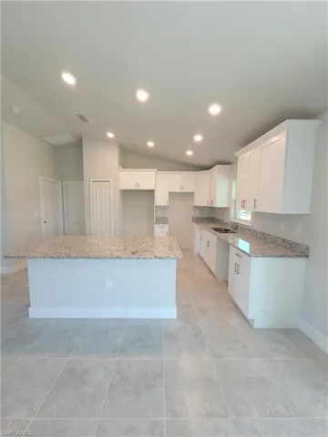 Kitchen featuring white cabinetry, a center island, and light tile patterned floors