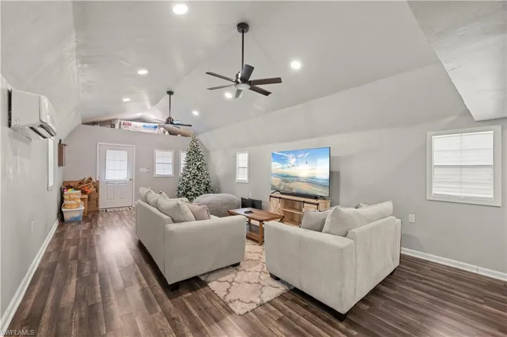 Featuring dark wood-style floors, ceiling fan, and recessed lighting