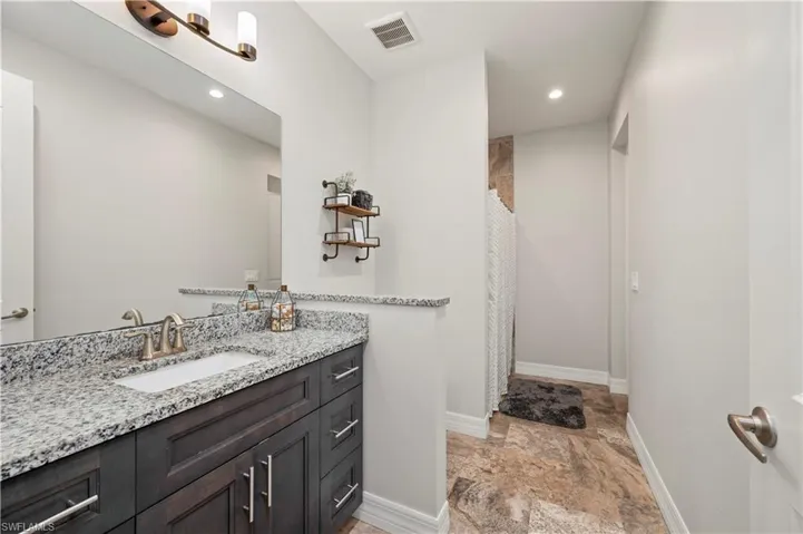 Full bathroom with a shower with curtain, vanity, recessed lighting, and light stone finish flooring