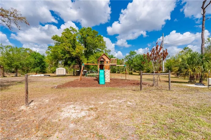 Communal playground featuring a storage unit and a lawn