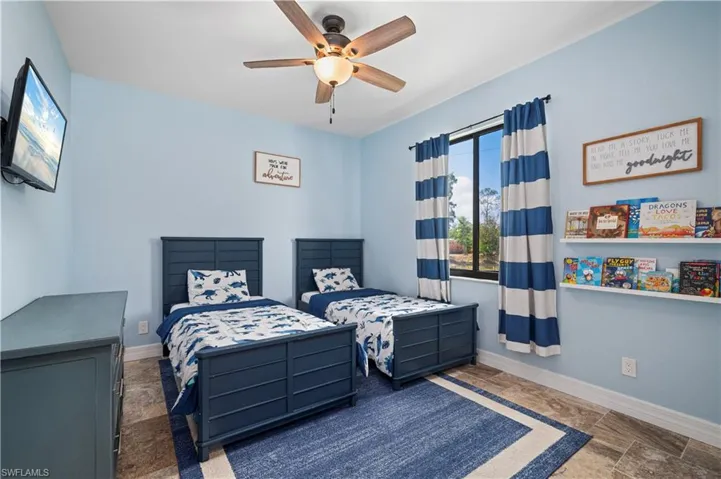 Bedroom featuring stone tile floors and ceiling fan