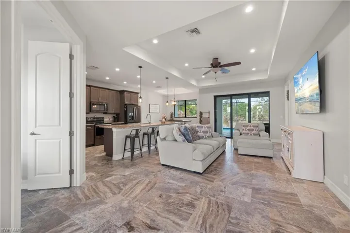Living area featuring a chandelier, a tray ceiling, and ceiling fan