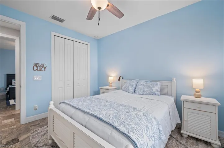 Bedroom featuring a closet, stone finish floors, and ceiling fan