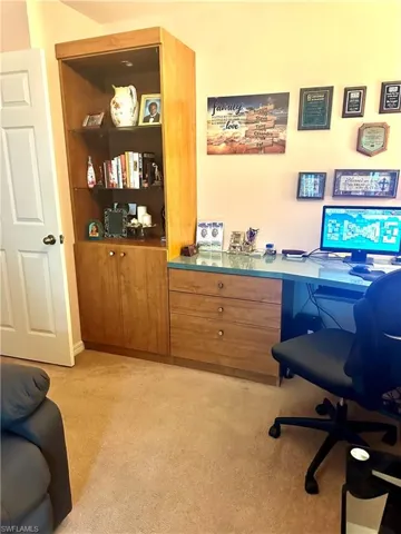 Office featuring light carpet and built in study area